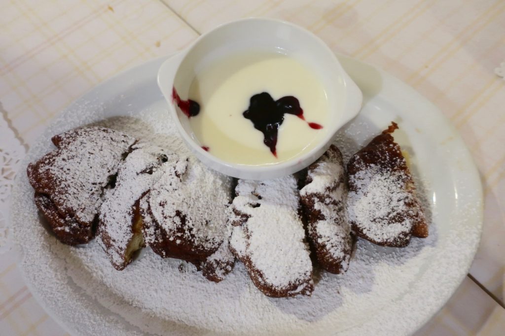 Dessert on the polish food tour. Racuchy is a Crispy warm apple fritters dusted with powdered sugar and served with a sour cream dipping sauce